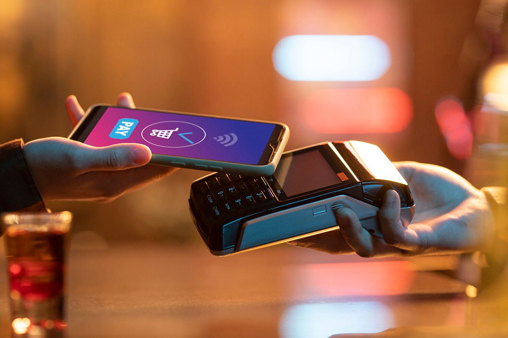 A customer making a contactless phone payment at a card terminal