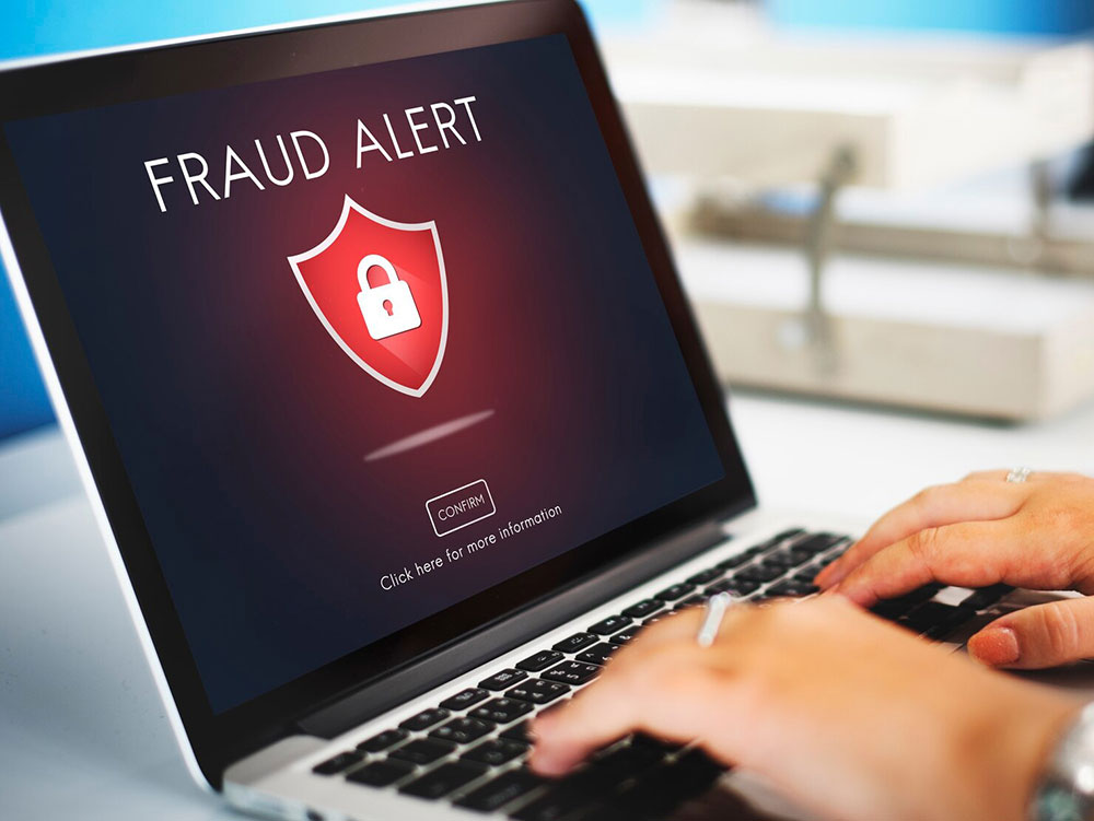 A customer at a laptop reviewing an on-screen fraud alert