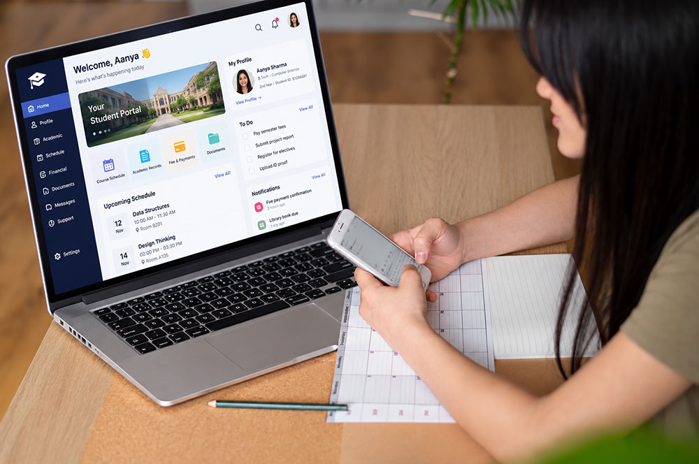 A student managing registration and fees in a student portal on a laptop while using a phone